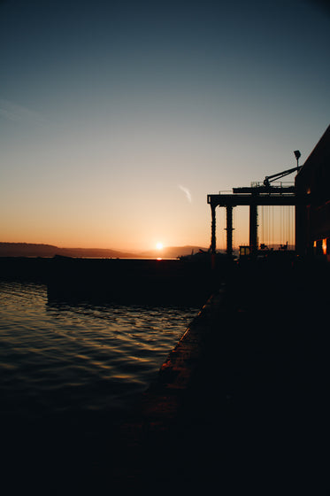 sunsets over still water at shore