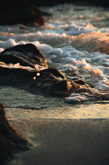 sunsetting on foamy rocks