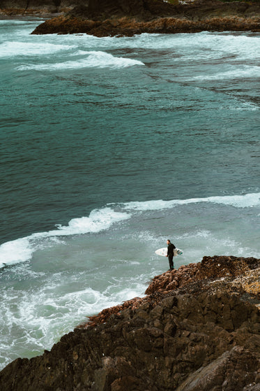 surfer by rocks