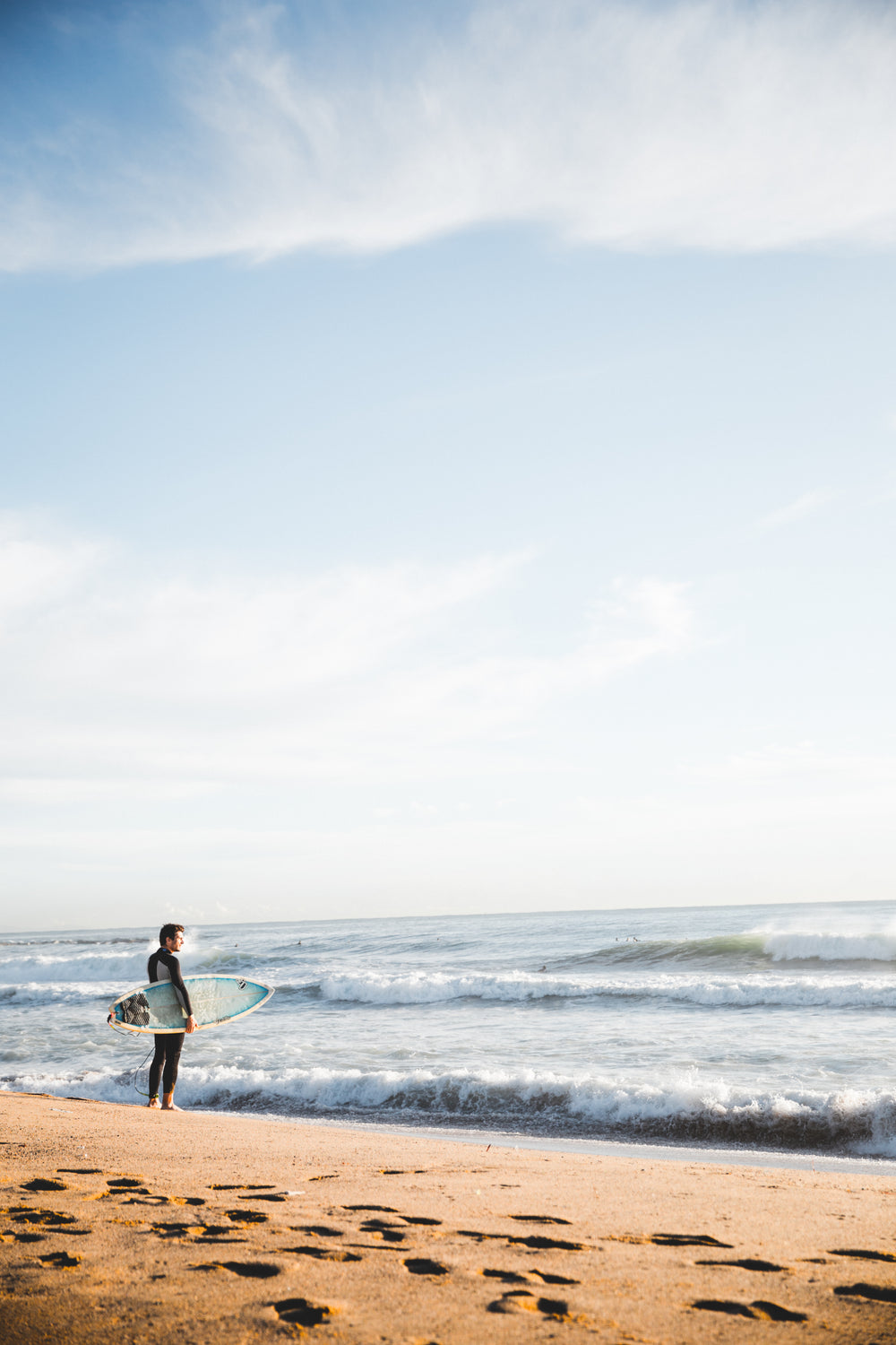 surfer standing by ocean