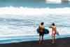 surfers stand on shore