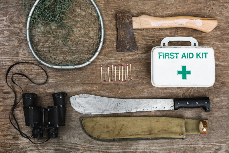 survival equipment flatlay - a knife, a knife, and a tool