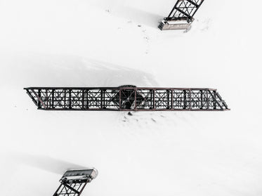 swing bridge above frozen river surrounded by snow
