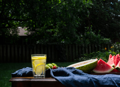 table of fresh fruit and lemon water outdoors