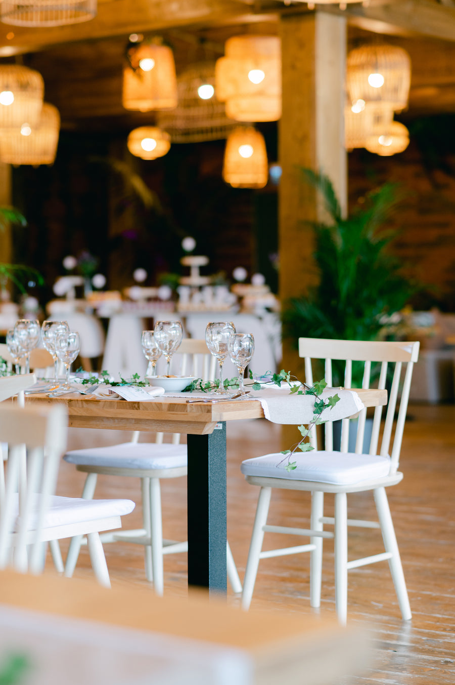 A long table set for an evening event with wine glasses