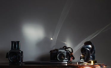 table with camera and film negatives and a laptop