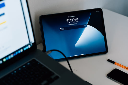 tablet with blue screen leans against a wall