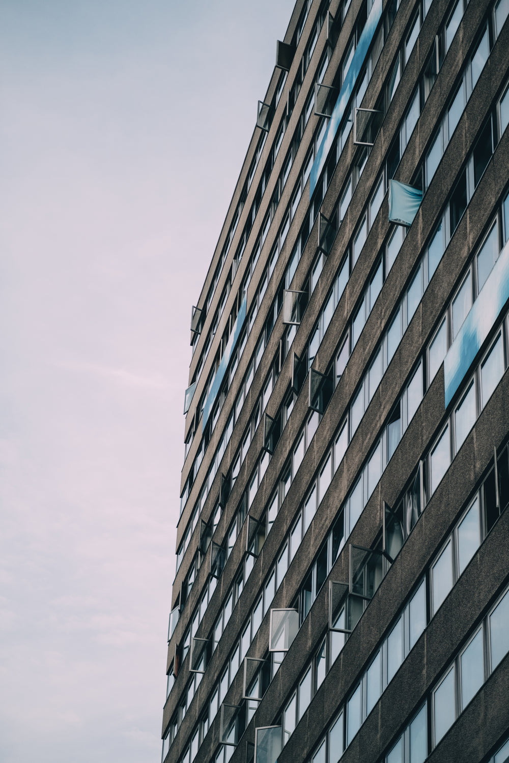 tall grey building with lines of reflective windows