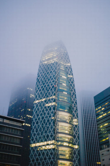 tall metal building at night disappearing into fog