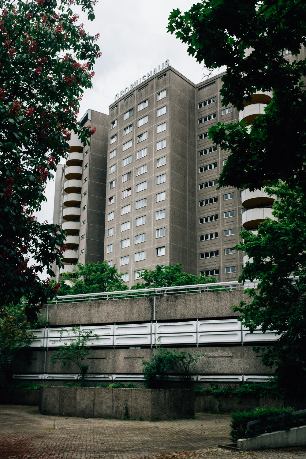 tall residential building framed by green trees