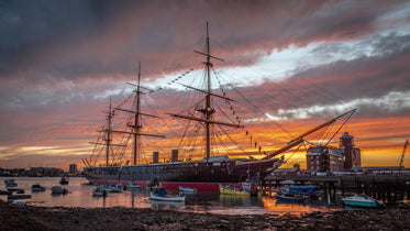 tall ship docked at sunset