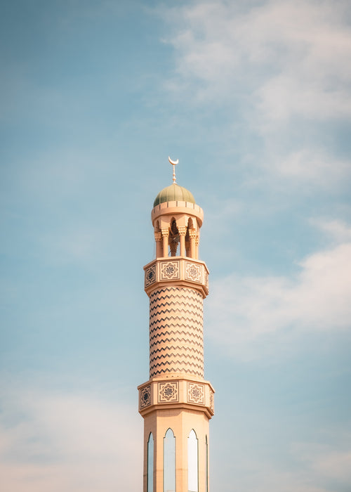 tall thin tower with a round roof against a blue sky