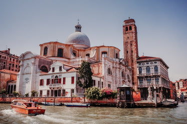 tall white building with rust colored water in front