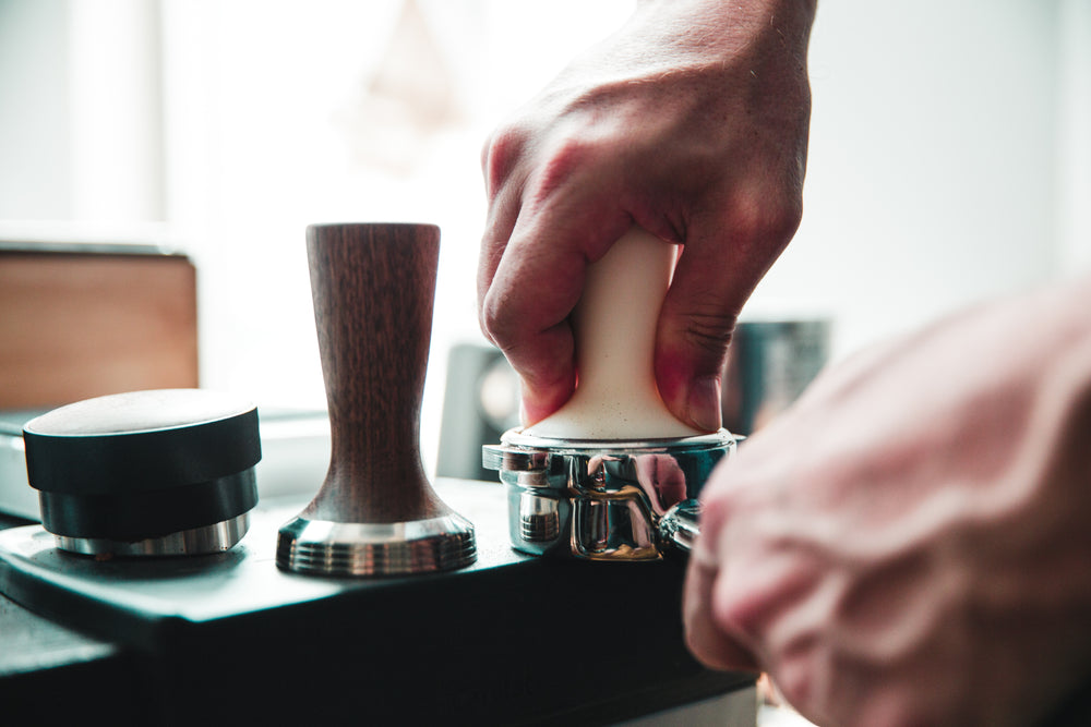 tamper being pressed into espresso machine wand