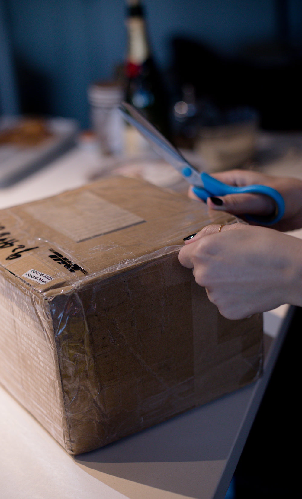 taped up cardboard box with a person holding scissors