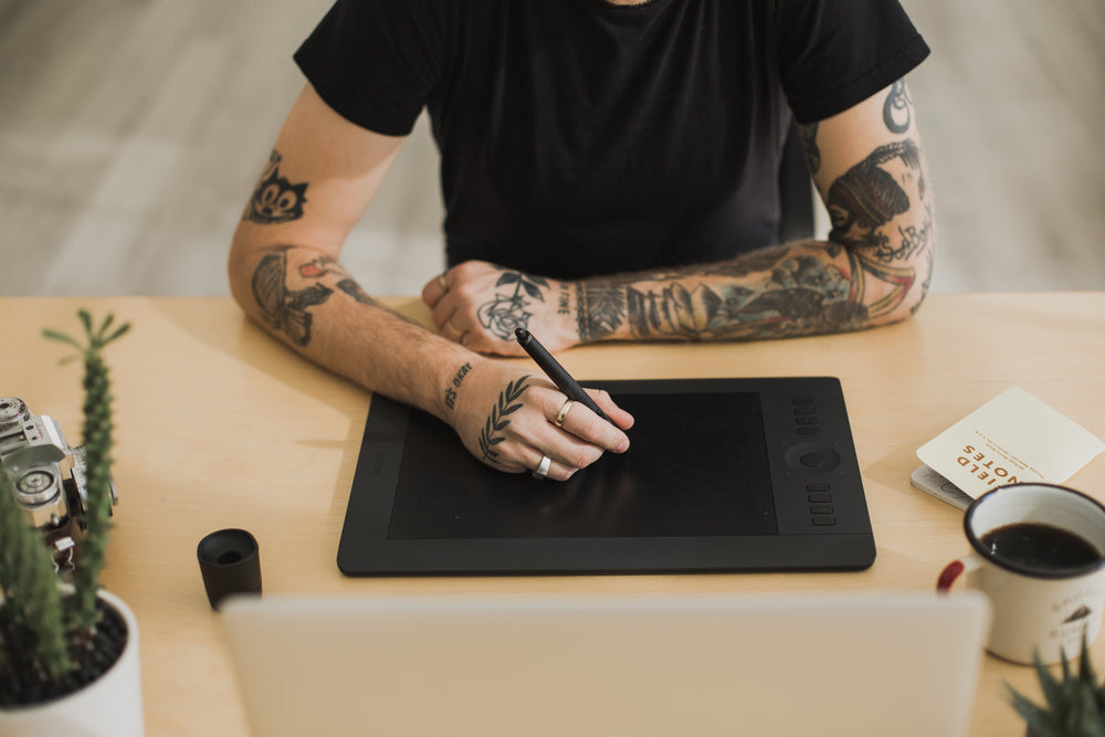 homem tatuado usando tecnologia criativa