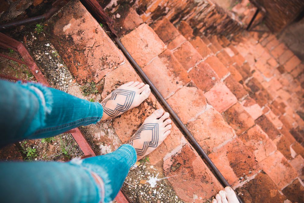 tattooed feet on steep stairs