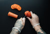 tattooed hands chop food with gloves