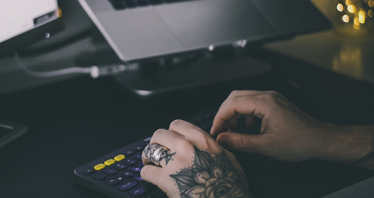 Tattooed hands Typing On Office Keyboard