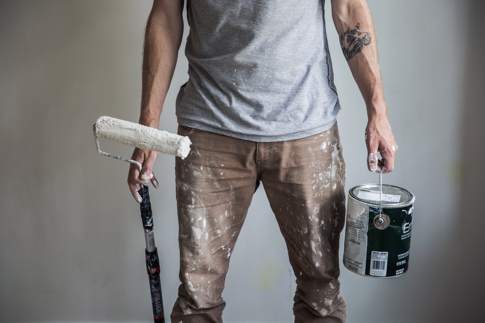 tattooed man painting walls