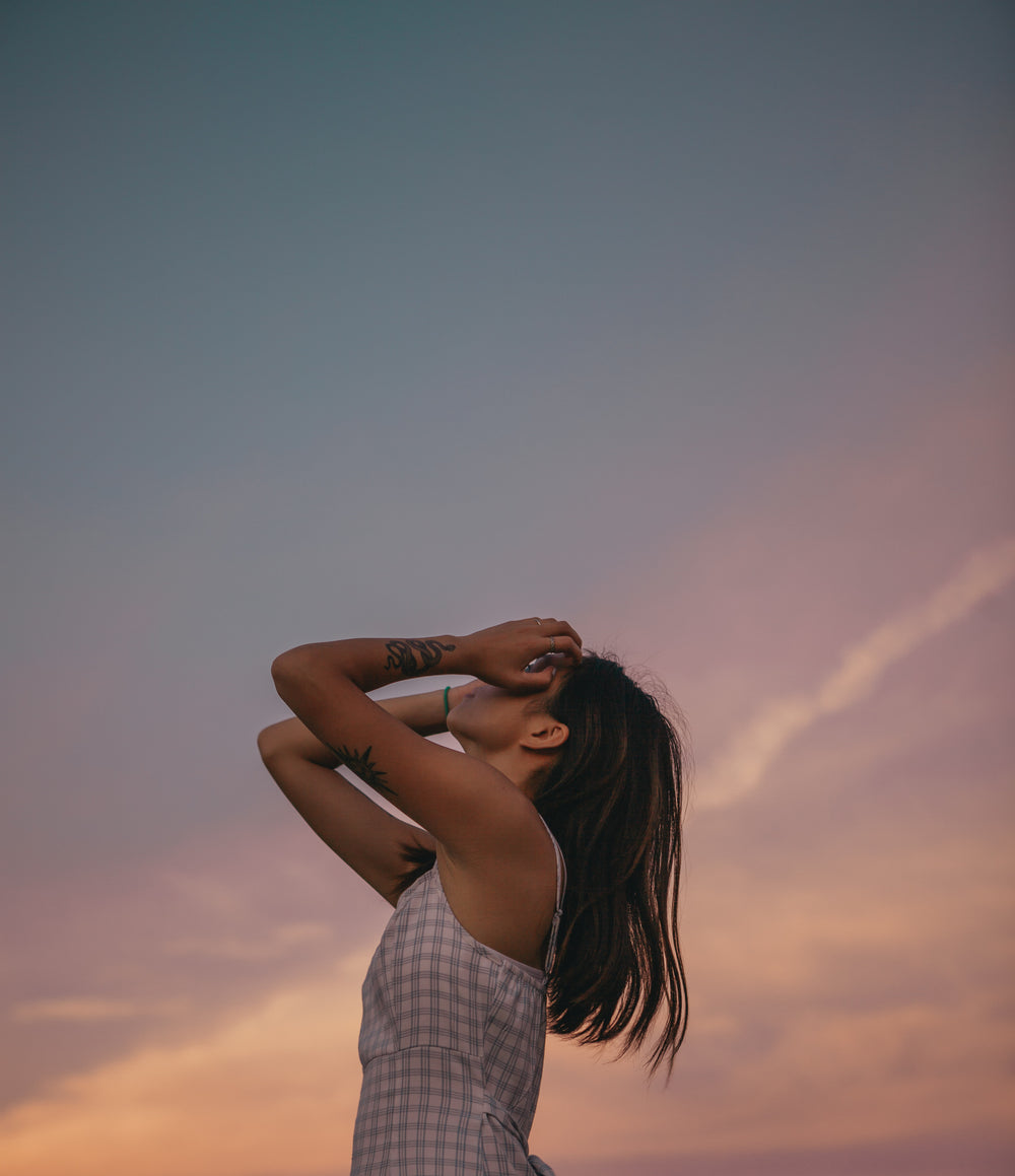 tattooed person posing at sunset