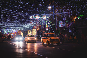 taxi and other small cars on a lit up city street