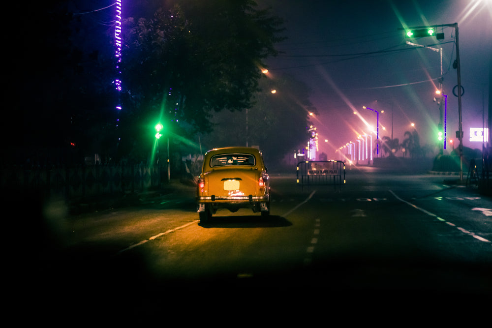 taxi cab drives down empty street at night