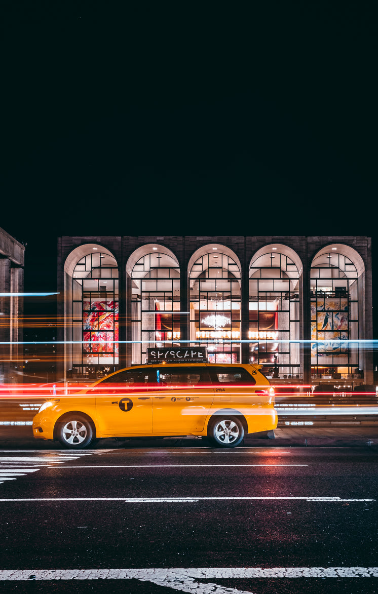 Taxi Races Past Urban Gallery At Night