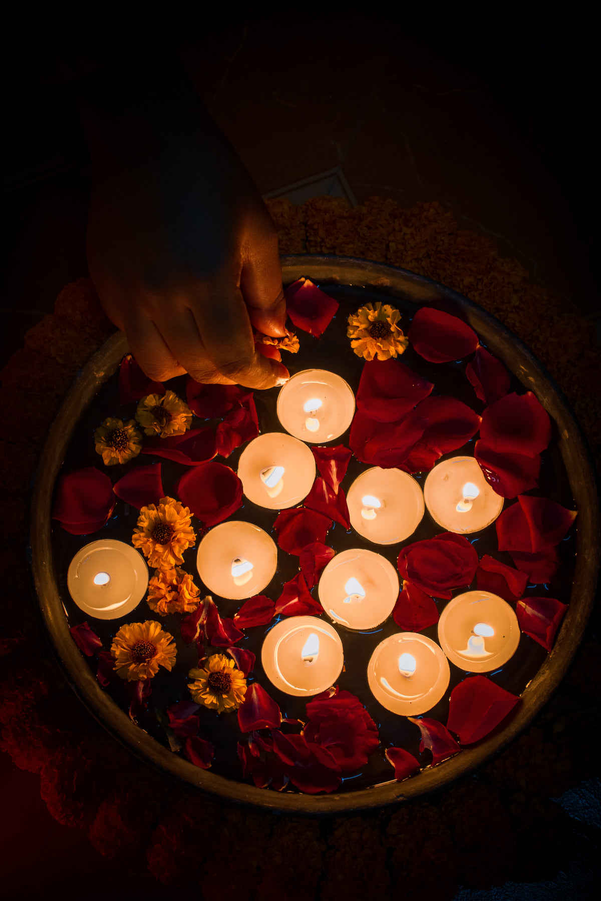 tealights and colorful flowers in dish