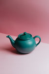 teapot against a lit pink background