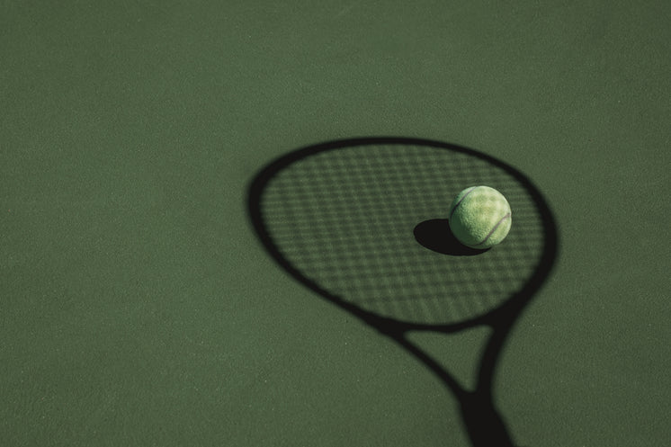 Tennis Ball Sits In The Shadow Cast By A Tennis Racket