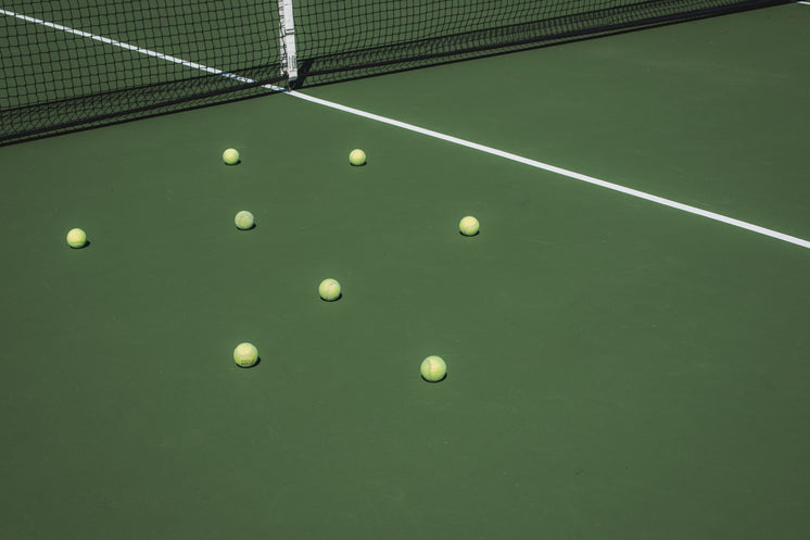 Tennis Balls Sit On The Green Court Bleached By The Sun