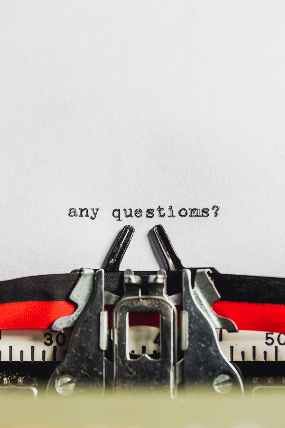 text on typewriter asks 'any questions?'