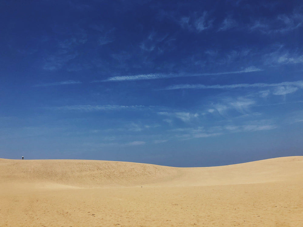 the blue sky meets the sandy dunes