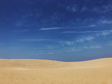 the blue sky meets the sandy dunes