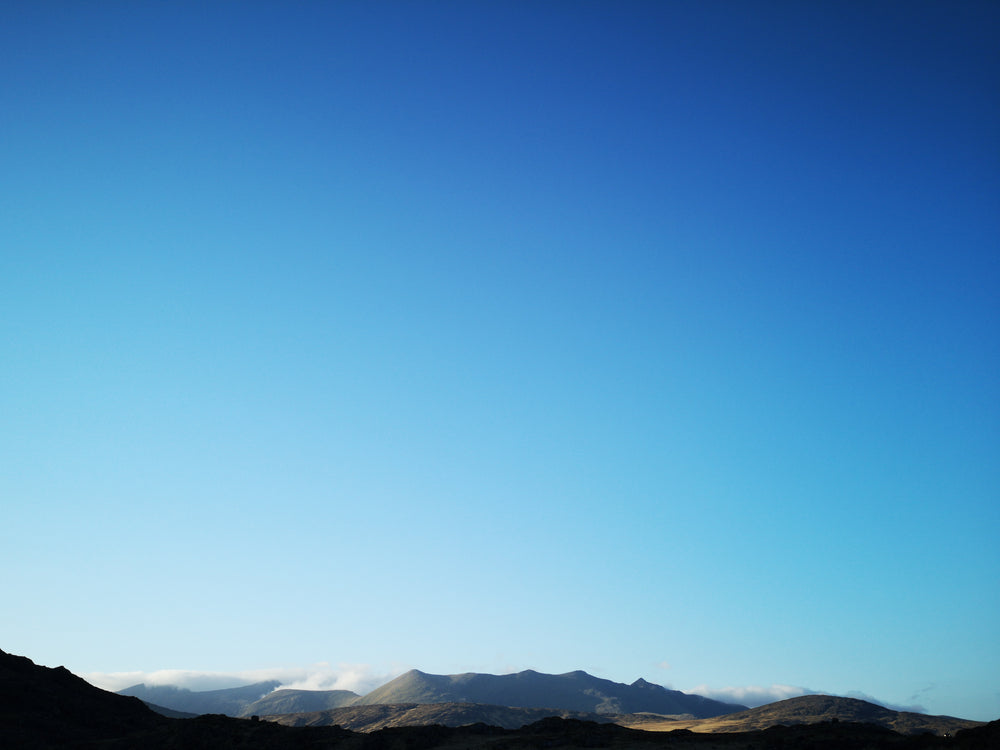 the blue sky over sunlit mountains