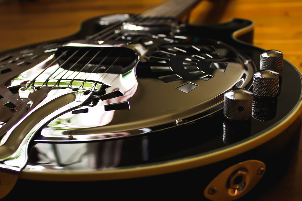 the chrome on a black guitar captures sunlight