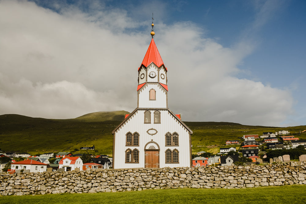 the church of sandavagur towers over the village houses