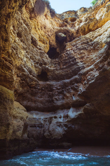 the craggy limestone cliff of a sandy bay