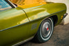 the front side of an olive green classic car