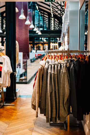 the inside of a store with grey sweaters stacked