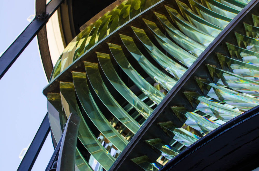 the panes of glass in a lighthouse lamp reflect sunlight