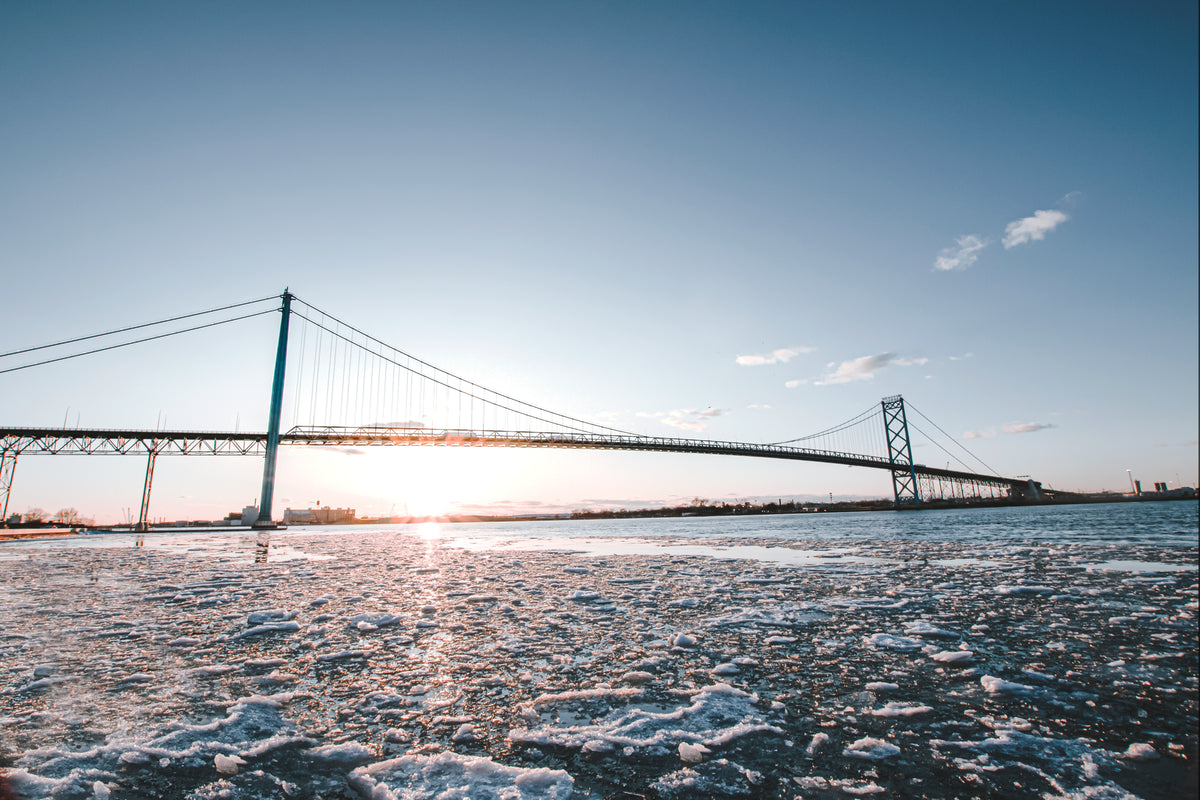 冬天，太阳落在一座长长的金属桥后面