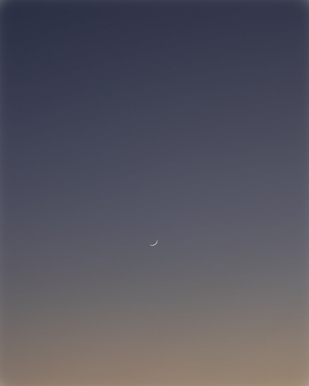 thin crescent moon in the dark blue sky