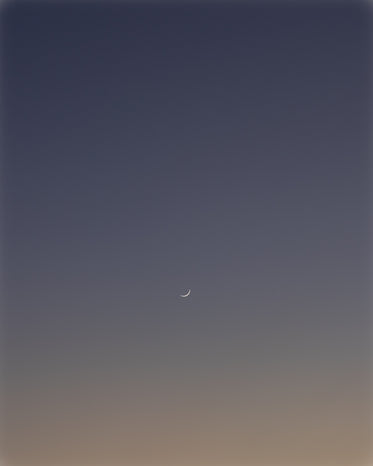 thin crescent moon in the dark blue sky