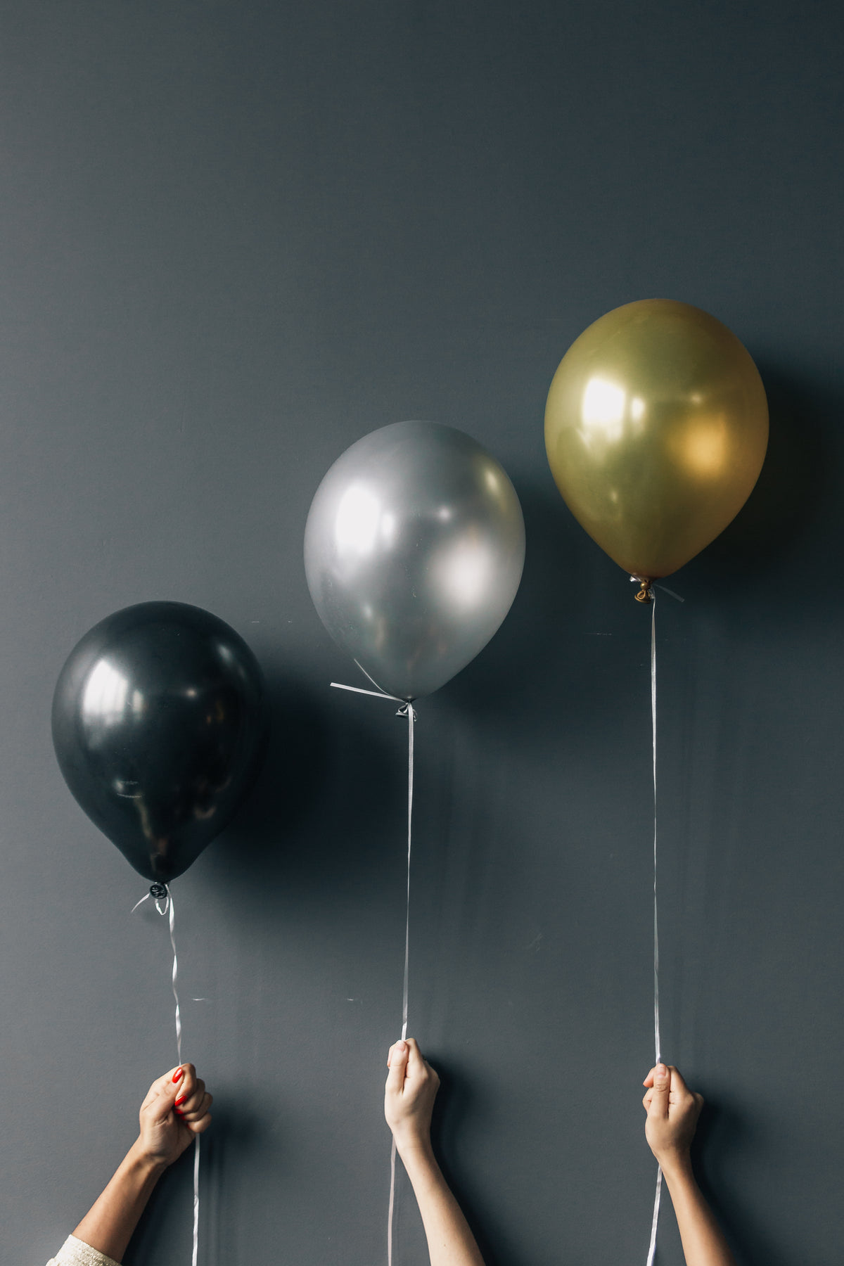 three balloons held against wall