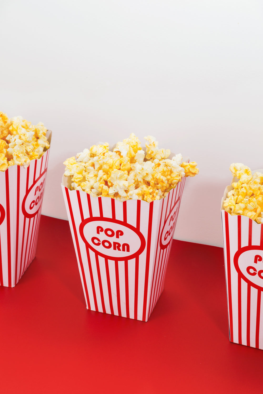 three boxes of crisp popcorn in candy-striped packaging