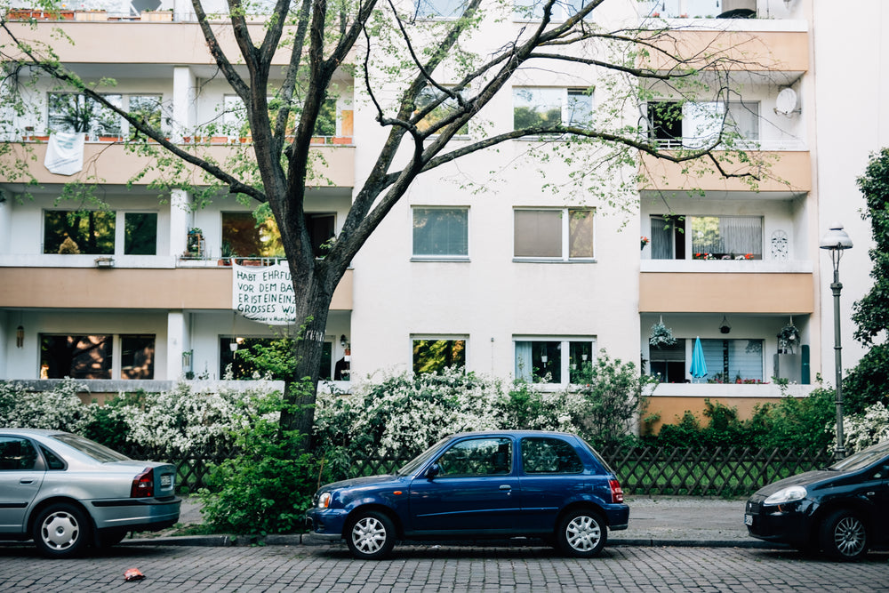 three cars are parked on stone paved street