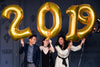 three friends holding 2019 helium balloons