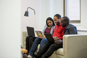 three friends working on couch